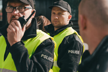 Close up of policemen speaking on the walkie-talkie during intervention