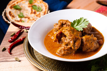 Food concept Homemade beef masala curry and roti paratha on wooden board with copy space