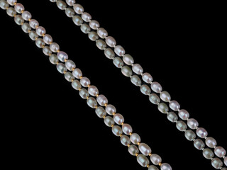 Lines of baroque pearls on black mirror background