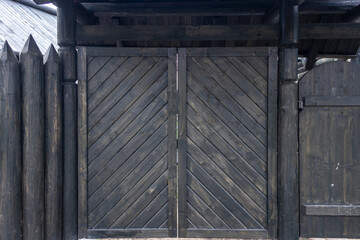 A protective fence made of logs with sharp upper ends, used in ancient Russia to protect against enemies. Traditional old Russian wooden construction of houses.
