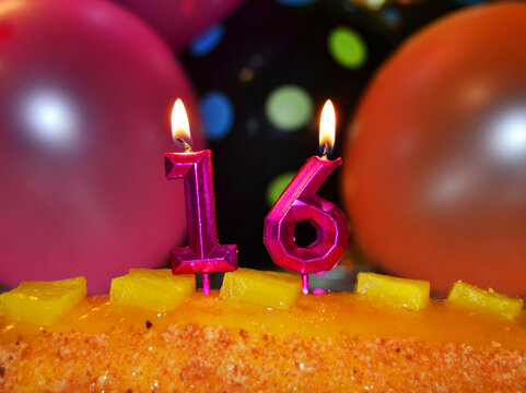 Celebration of the 16th birthday, with candles in the cake and balloons
