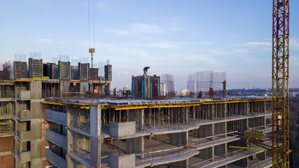 Workers on a high-rise building in the evening clog the formwork for pouring concrete.
