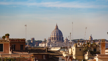 Fototapeta na wymiar View of the Basilica of St. Peter in the Vatican over the rooftops in Rome at sunrise