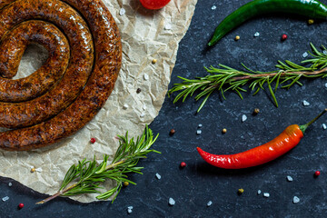 BBQ spiral sausage with tomatoes, rosemary, peppers, salt, garlic, spices and vegetables.