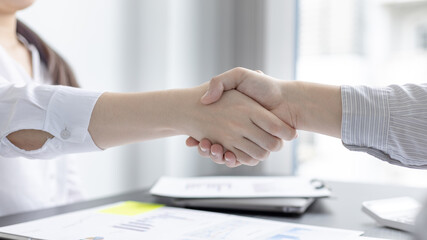 Business personage handshake, Asian business women congratulate on being a corporate partnership with European male investors, Friendship building, Sign language greetings, Business negotiation.