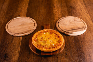 Pizza double cheese on the wooden background. 
