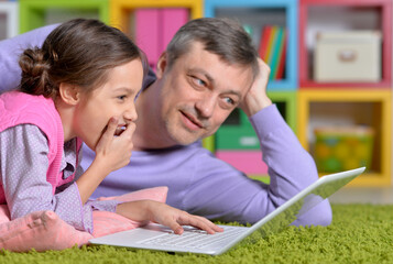 Father with little daughter using laptop