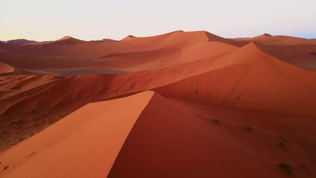 Drone shot of bright landscape in african desert. Amazing natural scene of wavy dunes created by wind. Incredible colourful barchans of different shape and size captured by drone.