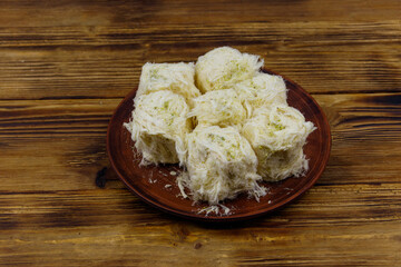 Traditional Turkish dessert Pismaniye with pistachios on wooden table