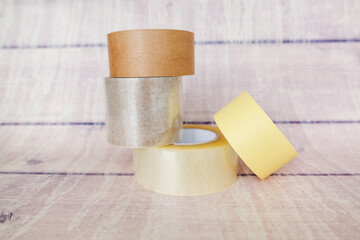 Manyerent scotch tapes on a wooden background.