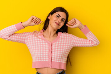 Young caucasian woman isolated on yellow background stretching arms, relaxed position.