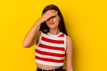 Young caucasian woman isolated on yellow background touching temples and having headache.