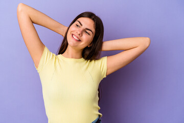 Young caucasian woman isolated on purple background feeling confident, with hands behind the head.