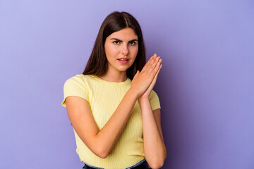 Obraz premium Young caucasian woman isolated on purple background feeling energetic and comfortable, rubbing hands confident.