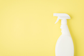 Top view photo of spray detergent white bottle without label on isolated yellow background with blank space