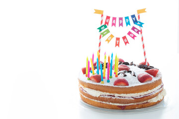 A colorful birthday cake with strawberries, candles and a happy birthday sign. White background, place for text. - 435213190