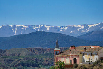 View of the Palace of the Gallardo in Marchal (Granada - Spain) with Sierra Nevada in the background. It is a pink stately house known as "Casa Grande", "Casa del Amo" or "Casa Rosa"