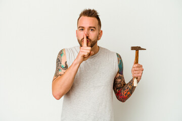 Young tattooed caucasian man isolated on white background keeping a secret or asking for silence.