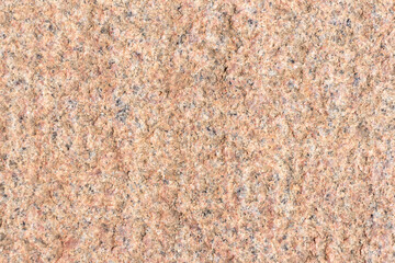 Abstract textured red granite background. Close-up view. Construction industry. Granite is rocks that is composed mostly of coarse-grained quartz and feldspars in varying proportions.