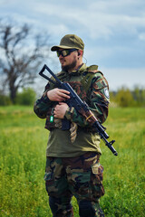 Fototapeta premium Russian soldier in a military foma holds a weapon in his hands