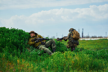 Soldiers during the battle in the field are hiding behind cover