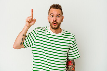 Young tattooed caucasian man isolated on white background pointing upside with opened mouth.