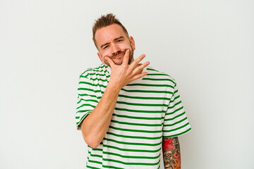 Young tattooed caucasian man isolated on white background doubting between two options.