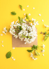 Cherry white flowers bouquet inside a envelope. Holiday, Mothers day gift concept. Spring background. Flat lay, Copy space.