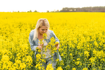 Fototapeta premium Portrait with a beautiful woman in rapeseed