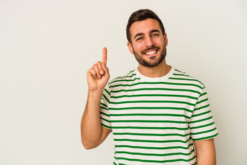 Fototapeta premium Young caucasian man isolated on white background showing number one with finger.
