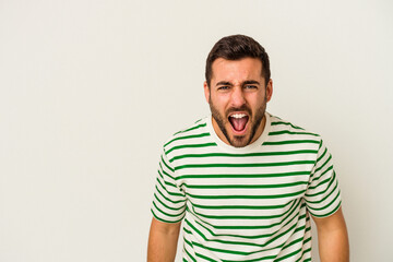 Obraz premium Young caucasian man isolated on white background shouting very angry, rage concept, frustrated.