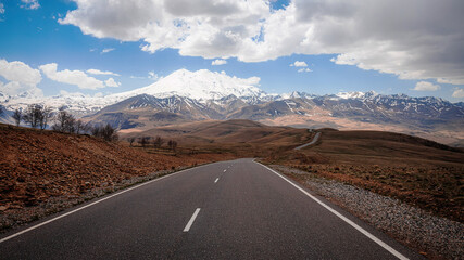 Elbrus And Green Hills with road At Sunny Summer Day. Dzhili-Su, Republic of Kabardino-Balkaria,North Caucasus, Russia.