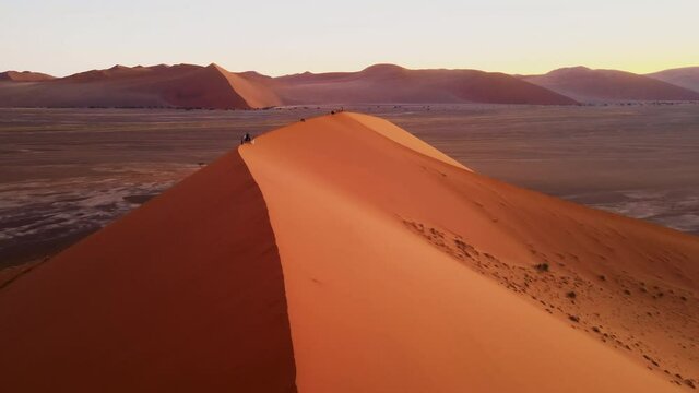 Drone shot of bright landscape in african desert. Amazing natural scene of wavy dunes created by wind. Incredible colourful barchans of different shape and size captured by drone.