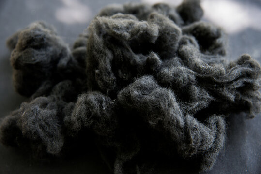 Black Polyester stable fiber with blurred green background