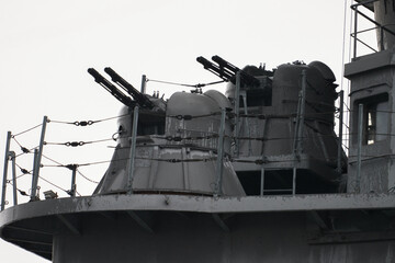 The upper part of the bow superstructure of a light cruiser with outdated models of paired automatic artillery installations.