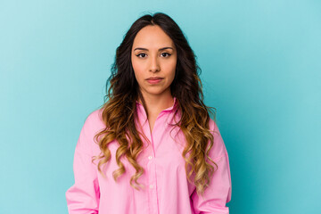 Young mexican woman isolated on blue background sad, serious face, feeling miserable and displeased.