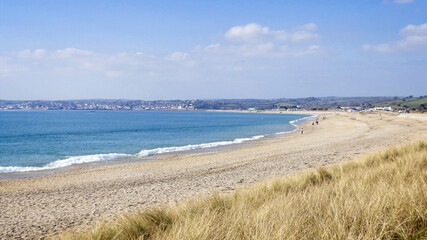 A near deserted Marazion beach and Mounts Bay looking towards Penzance, Cornwall, UK.