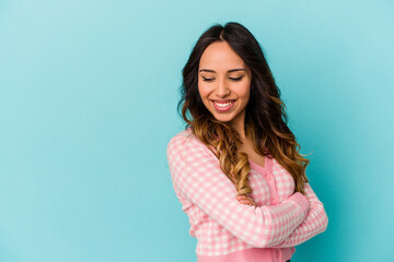 Obraz premium Young mexican woman isolated on blue background smiling confident with crossed arms.
