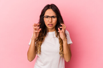 Young mexican woman isolated on pink background upset screaming with tense hands.