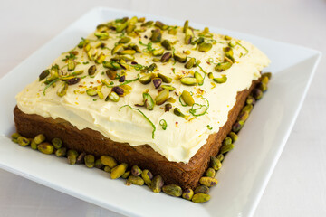 Square lime and pistachio cake decorated with lime peel and pistachios