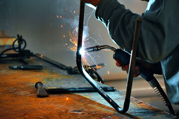 This is a welder working in a welding shop and sparks are flying.