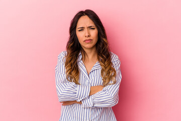 Fototapeta premium Young mexican woman isolated on pink background suspicious, uncertain, examining you.