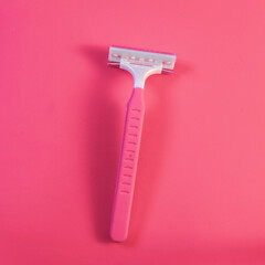 Pink razor for women symbol of hygiene and body care on a pink background