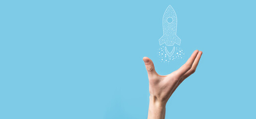 Male hand holding digital transparent rocket icon.Startup business concept. Rocket is launching and soar flying.Concept of business idea.