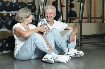 Senior couple drinking in gym