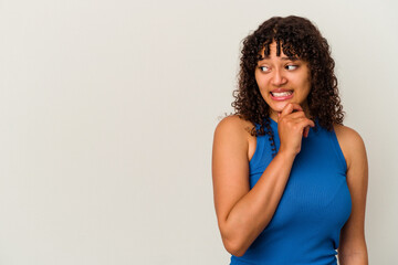 Young mixed race woman isolated on white background touching back of head, thinking and making a choice.