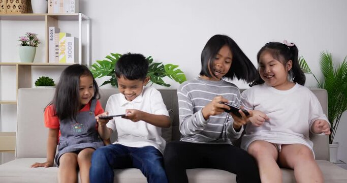 Children play mobile phones And tease around on sofa