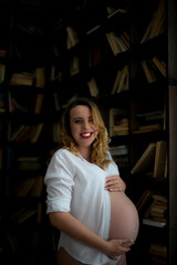happy pregnant woman eighth ninth month of pregnancy hugging her belly with her hand 