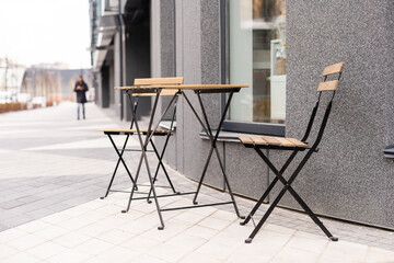outdoor table and two chairs near the wall at coffee shop,