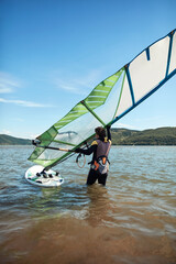 Naklejka premium Windsurfer surfing on a windy summertime day at the river.